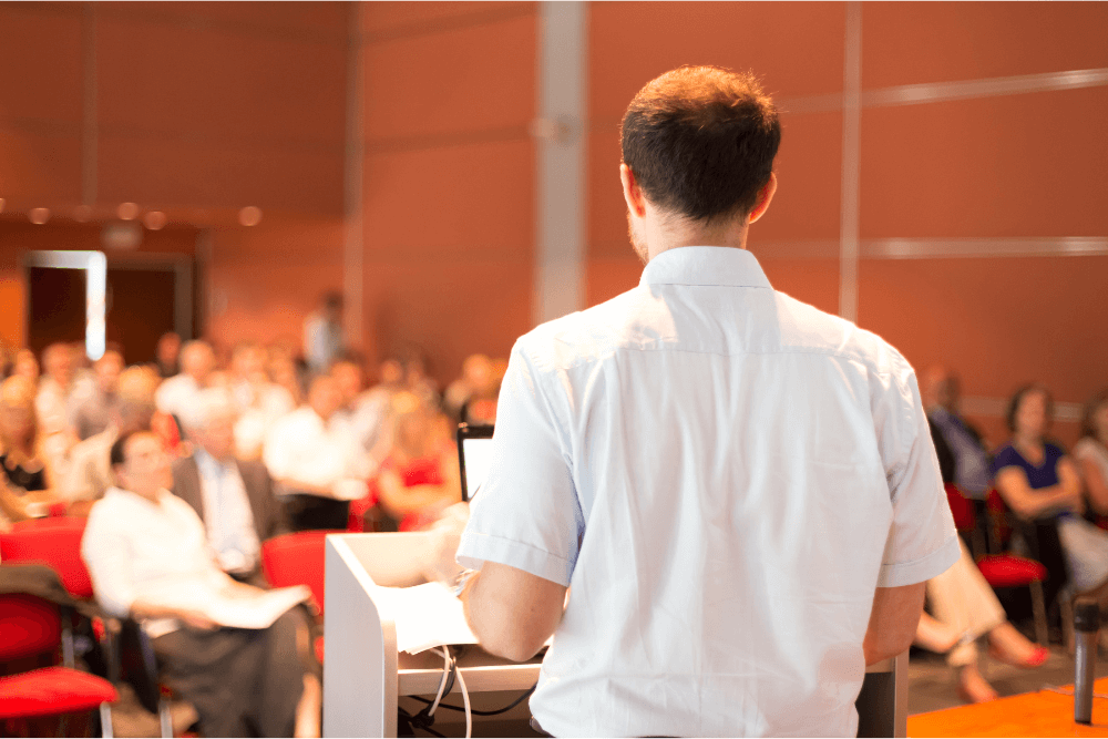 homem palestrando em um evento jurídico